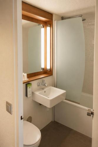 a bathroom with a sink and a toilet and a mirror at Hôtel Campanile Orléans Nord - Saran in Saran