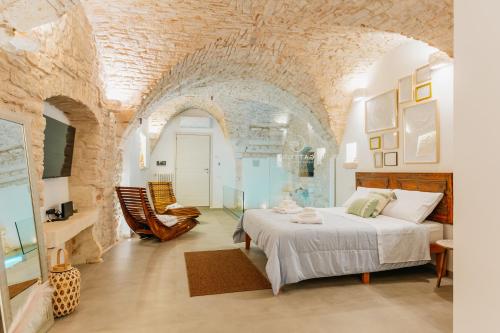 a bedroom with a bed and a stone wall at Gattoni Suite by Rentbeat in Martina Franca