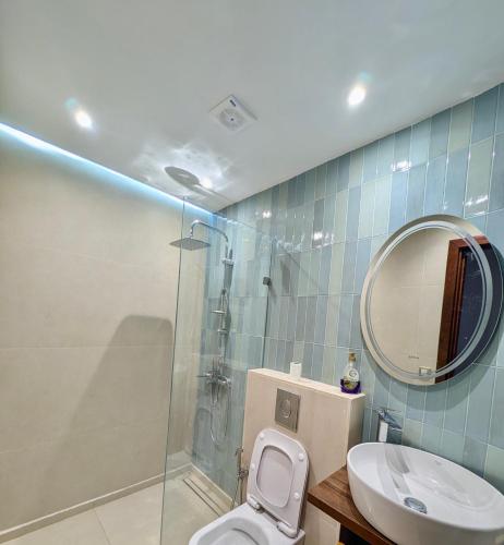 a bathroom with a shower and a toilet and a mirror at Andalucia Family-Only Aparthotel in Cabo Negro