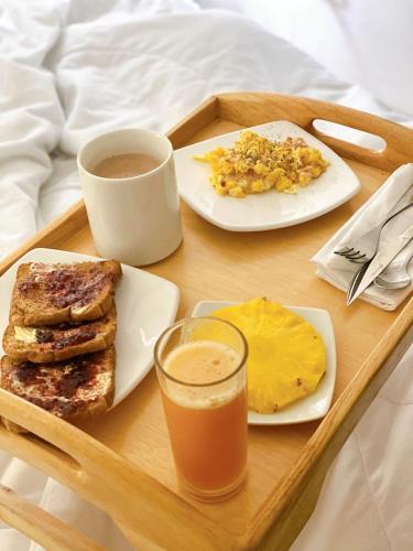 a tray of breakfast foods and a drink on a bed at Hostal Jireh in Manta