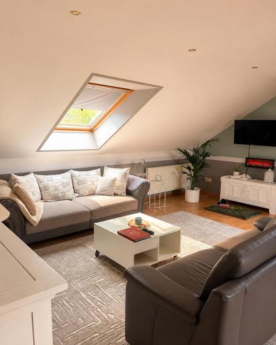 a living room with a couch and a table at Green Door Loft Stilvolles 160 m2 Apartment Balkon Gartenblick Workstation Hundefreundlich in Ibbenbüren