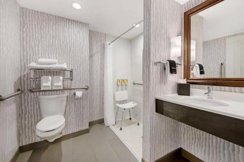 a bathroom with a toilet and a sink and a mirror at Best Western Plus Agate Beach Inn in Newport