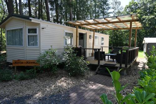 a small white tiny house with a pergola at Kota Kiva in Hulshorst