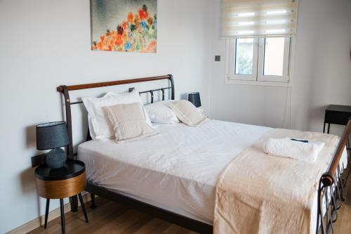 a bedroom with a bed with white sheets and a window at Exclusive Villa with Pool in Káto Ássos