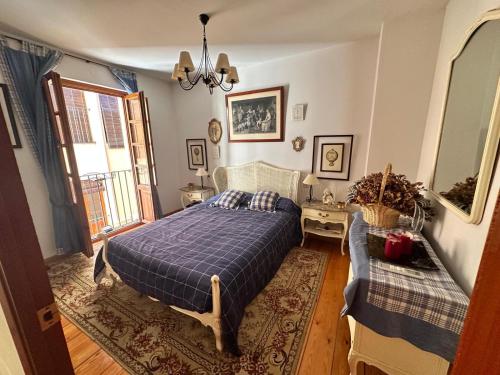 a bedroom with a bed with a blue comforter at Casona de la Tauna in Sos del Rey Católico