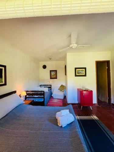 a bedroom with a bed and a living room at Bocaina Sítio da Vovó in Engenheiro Paulo de Frontin