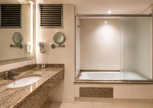 a bathroom with two sinks and a shower at Cedro Hotel in Londrina