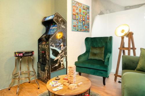 a living room with a video game machine and a green chair at 120m2 l Golden Castle Loft l Old Town l Thun in Thun