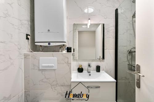 a white bathroom with a sink and a mirror at Les Jardins, Golfe-Juan in Vallauris