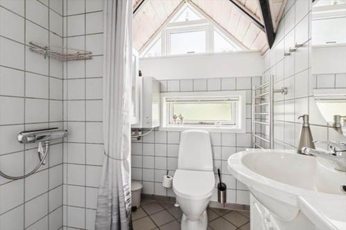 a bathroom with a toilet and a sink and a window at 1395-Thisted-Revlingvej-5 in Nørre Vorupør