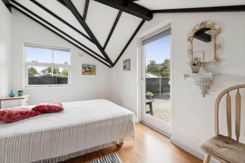 a bedroom with a white bed and a window at 1395-Thisted-Revlingvej-5 in Nørre Vorupør