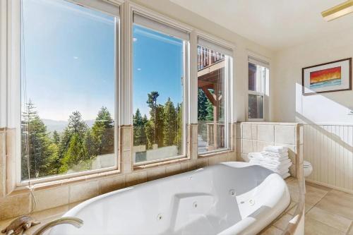a bath tub in a bathroom with a large window at Pinetree Palace in Lake Arrowhead