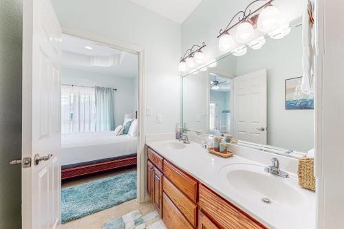 a bathroom with a sink and a mirror and a bed at Sunset Over Paradise in South Padre Island