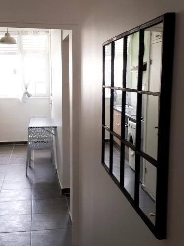 a mirror in a room with a table and a chair at Perle proche gare maritime et croisières in Pointe-à-Pitre