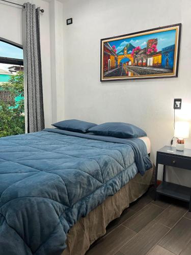 a bedroom with a bed with blue sheets and a window at casa borde de lago4 in Panajachel