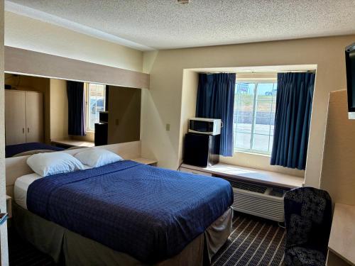 a hotel room with a bed and a window at Chadron Inn & Suites in Chadron