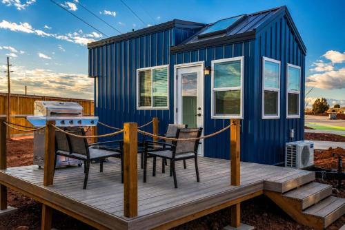 a tiny house with a table and chairs on a deck at Tiny Home with Private Hot Tub, Zion Adventure Base in Apple Valley