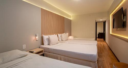 a hotel room with two beds and a television at Mirasol Copacabana Hotel in Rio de Janeiro