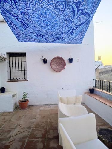 a room with white chairs and a blue ceiling at Ideal Perros Patio Privado Casa Jaruf in Arcos de la Frontera