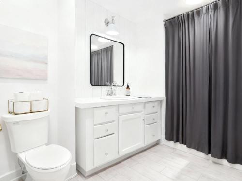 a bathroom with a toilet and a sink and a mirror at Vail Pines Stay in Vail