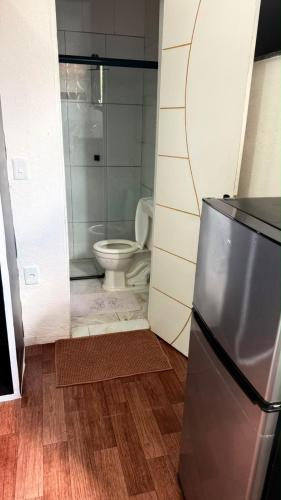a small bathroom with a toilet and a refrigerator at Studio completo, perto da praia! in São Luís