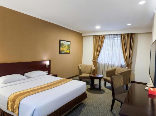 a hotel room with a bed and a desk at Citra Boutique Hotel Cikarang in Cikarang