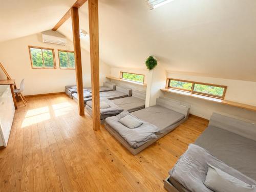 a room with four beds in it with windows at サウナパラダイス富山 in Minamiboso