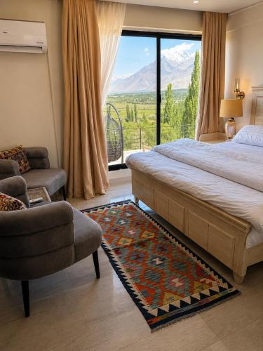 a bedroom with a large bed and a chair and a window at Lamhay Private lodges in Skardu