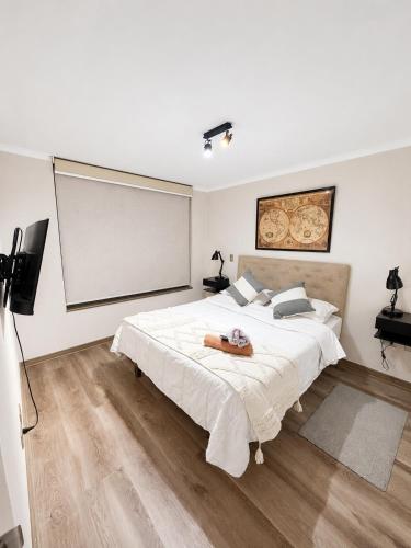 a bedroom with a large white bed and a screen at Extraordinario depto ejecutivo in Los Ángeles