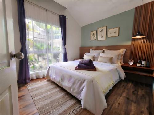 a bedroom with a large white bed with a window at Zen Ocean Villa -Sri Thanu in Ko Phangan