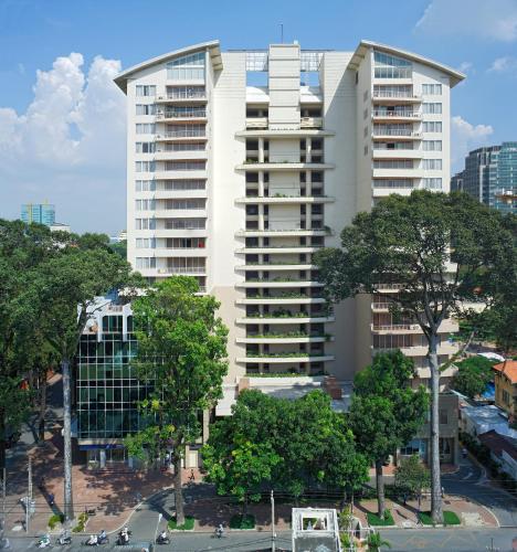 a tall white building with trees in front of it at Somerset Chancellor Court Ho Chi Minh City in Ho Chi Minh City
