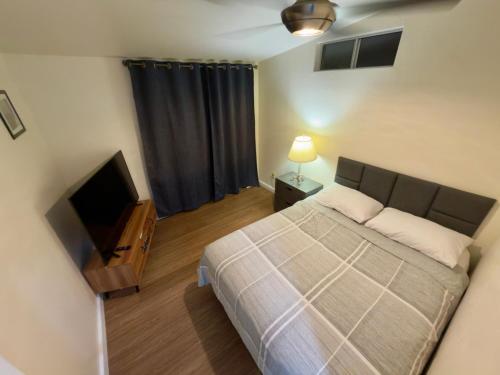 a bedroom with a bed and a flat screen tv at Naya homes: The estero beach. in Ensenada