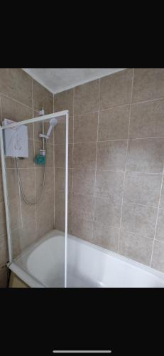 a bath tub with a shower in a bathroom at Central stay in Nottingham