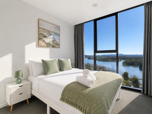 a bedroom with a large bed and a large window at Lakeview on Grazier in Belconnen