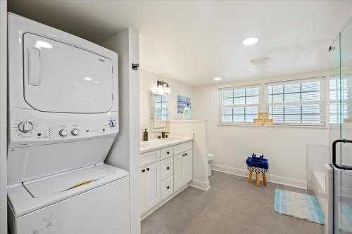 a white kitchen with a sink and a refrigerator at The Pearl in Pensacola