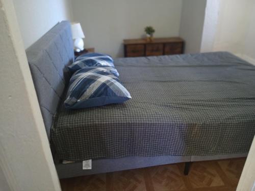 a bedroom with a bed with blue sheets and pillows at Nice Guest House in Artesia
