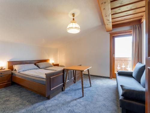 a bedroom with a bed and a table and a chair at Grünbichel Hof I in Uttendorf
