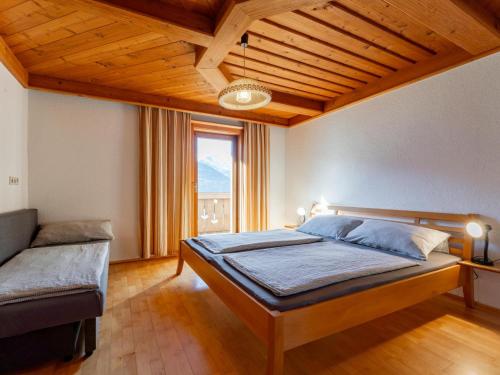a bedroom with a bed and a large window at Grünbichel Hof II in Uttendorf
