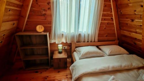 a bedroom with two beds in a log cabin at Riverside Rooms in Šavnik