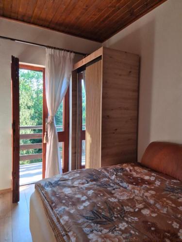 a bedroom with a bed and a large window at Villa DORA in Vrbovsko