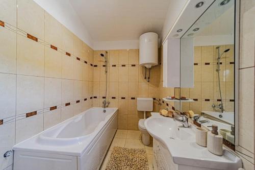 a bathroom with two sinks and a tub and a toilet at Apartments by the sea Brna, Korcula - 561 in Smokvica