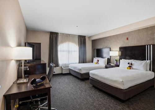 a hotel room with two beds and a desk at Grand Legacy At The Park in Anaheim
