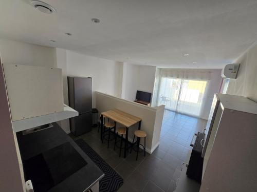 a kitchen with a small table and a kitchen with a refrigerator at Le Canetois in Canet-en-Roussillon