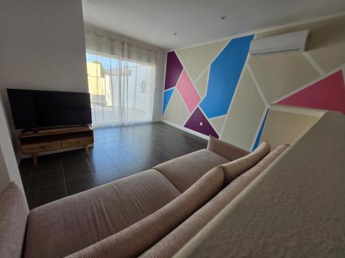 a living room with a couch and a flat screen tv at Le Canetois in Canet-en-Roussillon