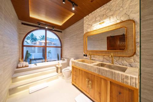 a bathroom with a sink and a mirror at Casa Maddu in Tegalalang