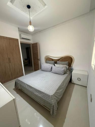 a bedroom with a bed in a white room at Triplex résidence tilel chott mariem in Sousse