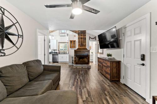 a living room with a couch and a flat screen tv at Delightful Cabin Loft Fire Pit & BBQ Julian in Julian