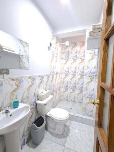 a bathroom with a toilet and a sink at Apartamentos Pachatusan in Pisac