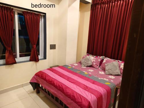 a bedroom with a bed with red drapes at The single room for two in Madikeri