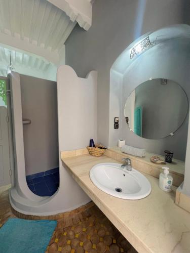 a bathroom with a sink and a mirror at Riad Darko in Essaouira
